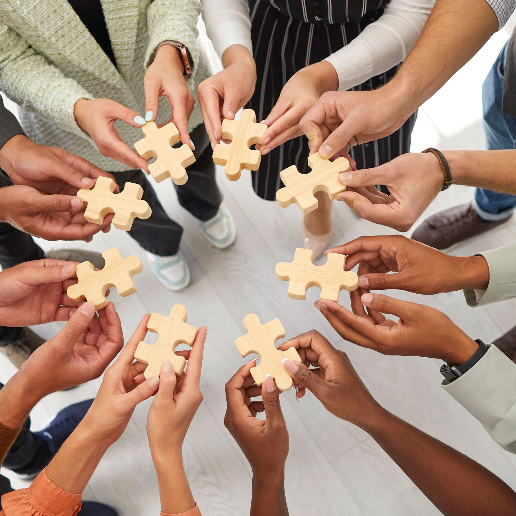 Hænder der hver holder en puslespilsbrik mod hinanden