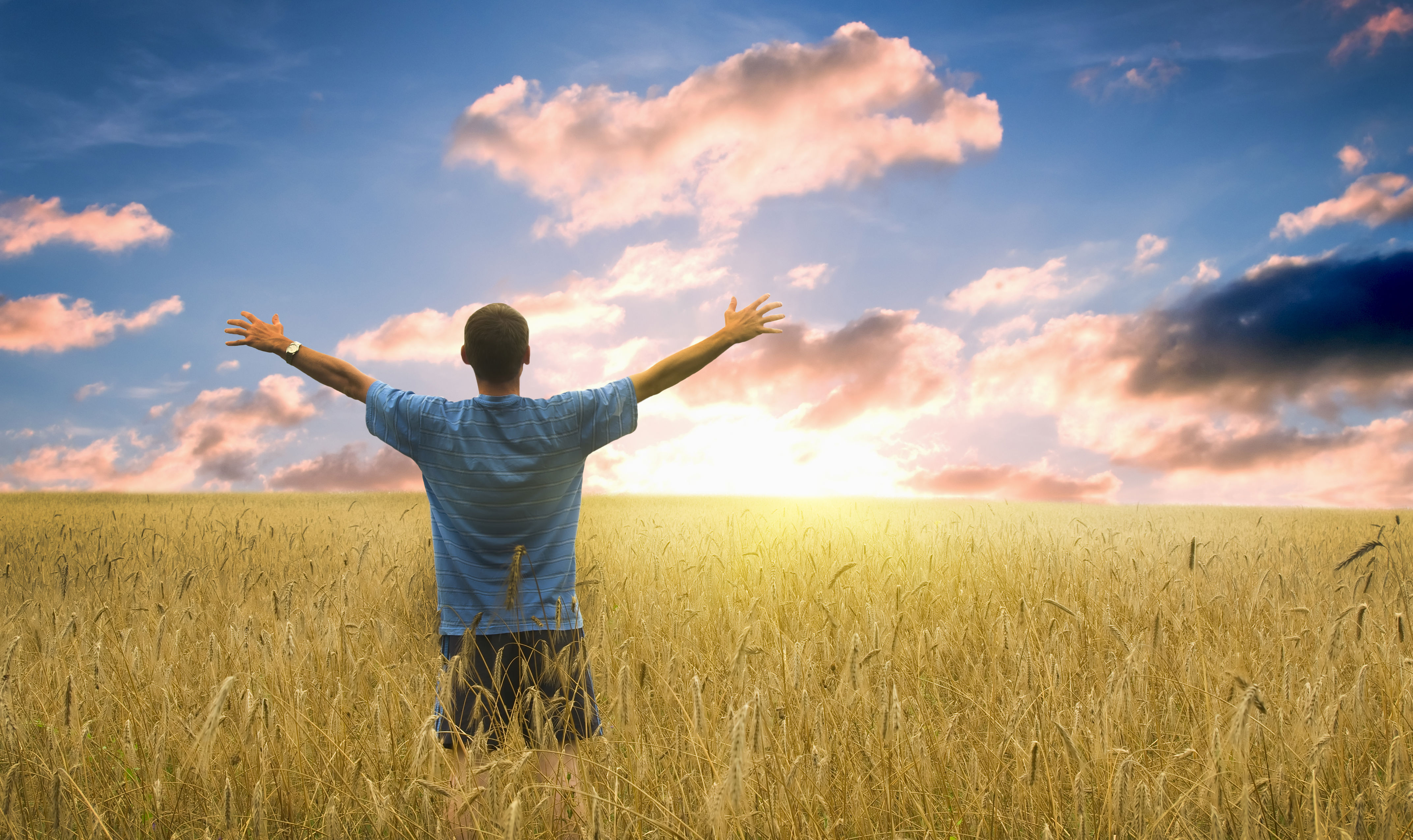 Mand der ser på horisonten med arme ude