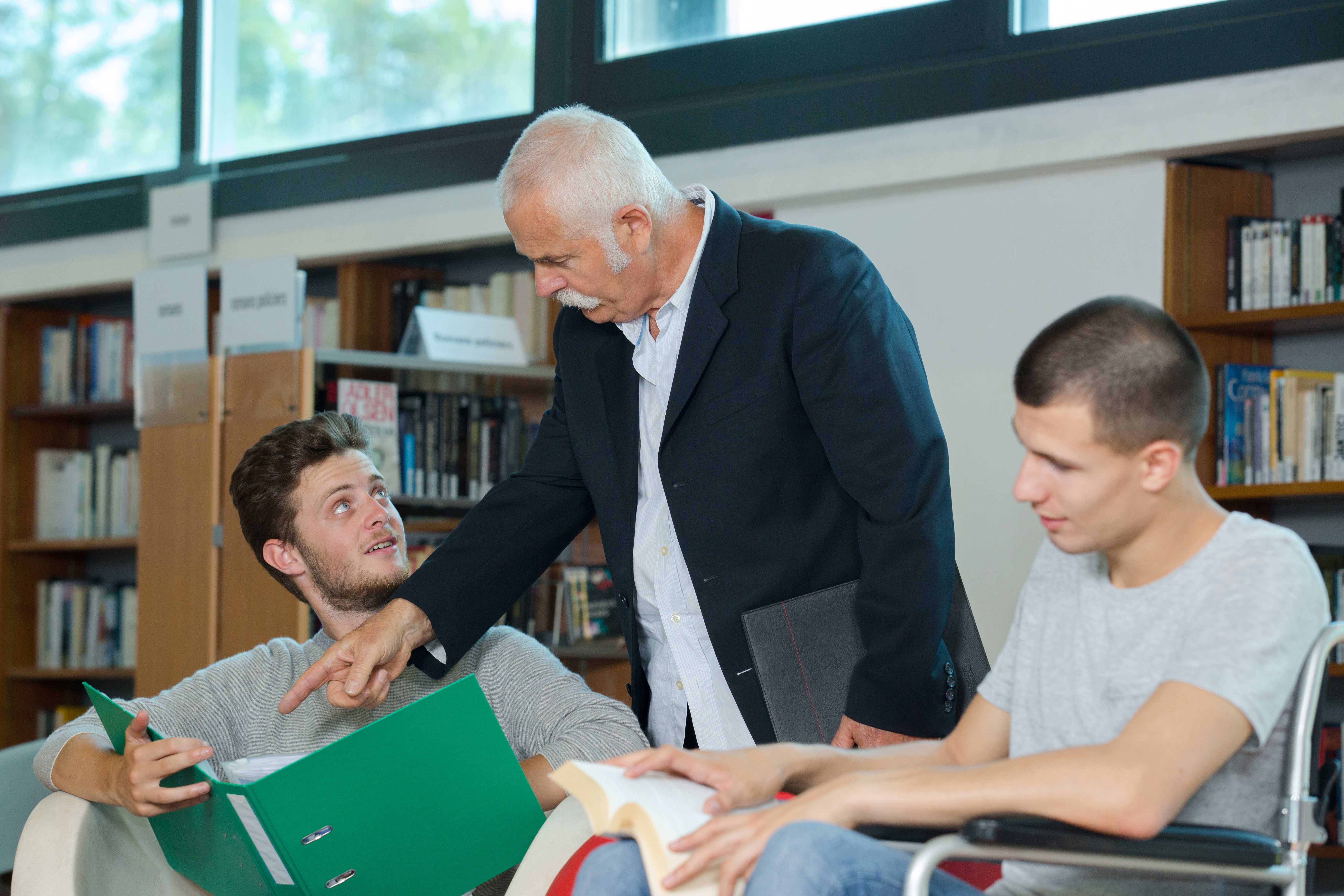 Tre mænd der kigger i bøger