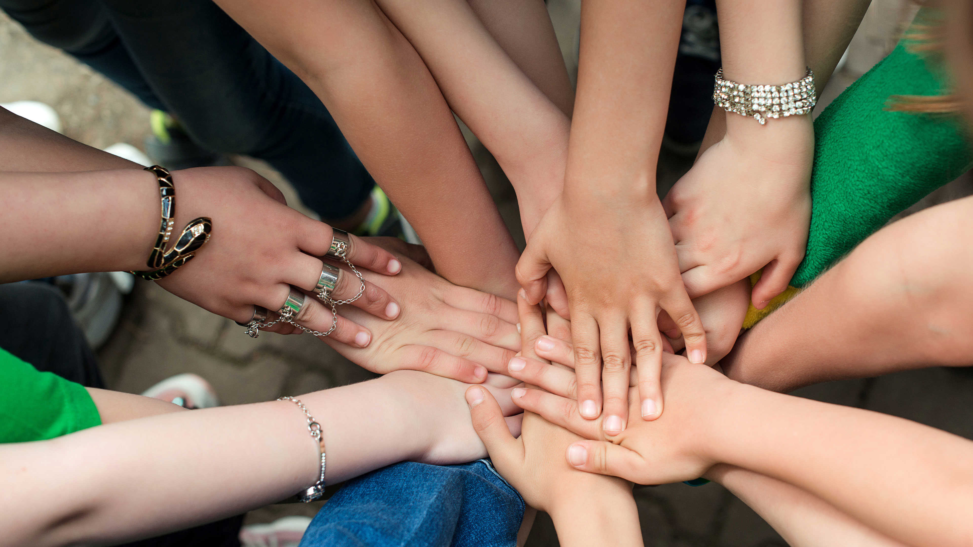 En masse unge der holder hænderne sammen