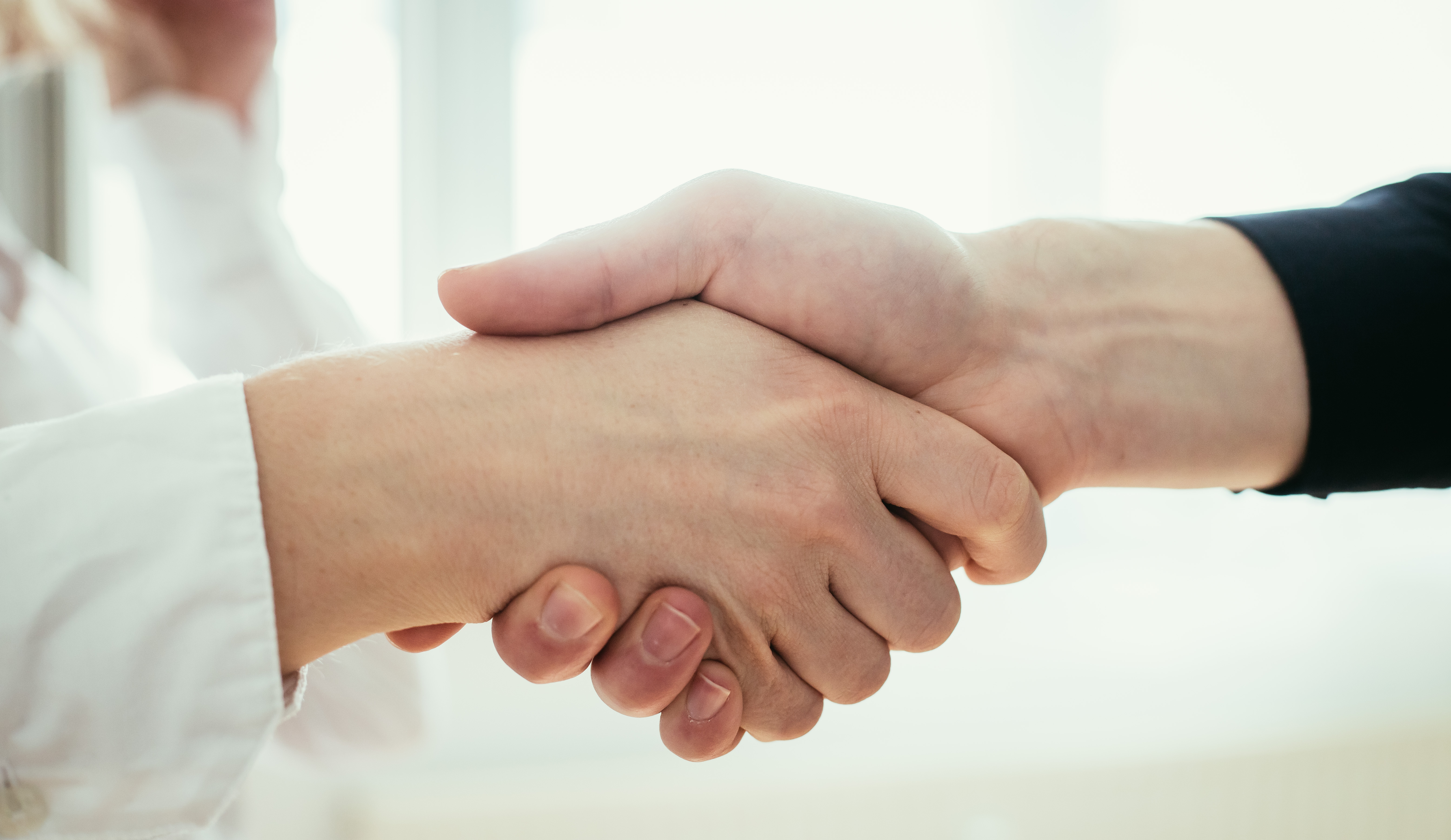 Håndtryk mellem to mennesker
