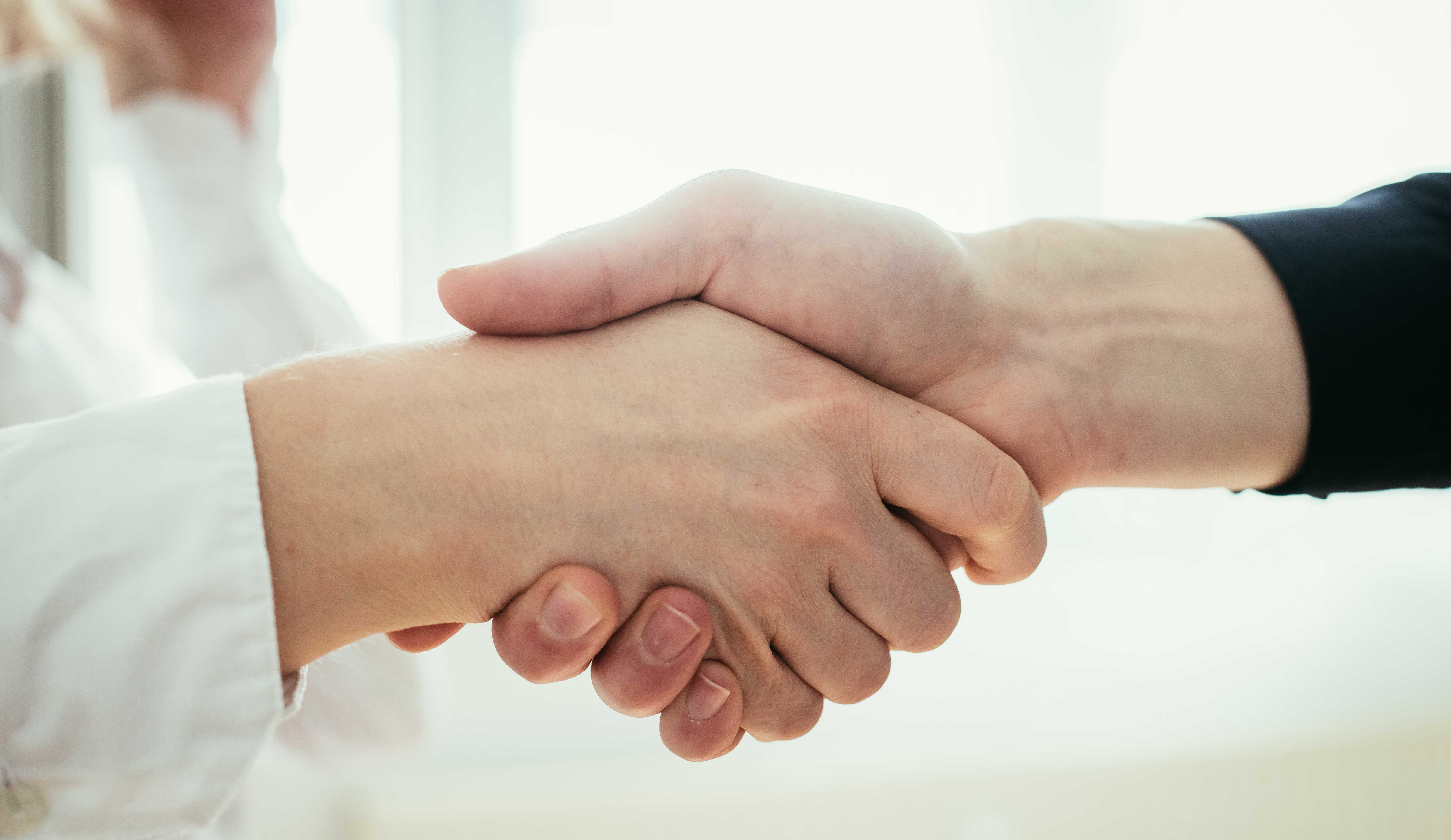 Håndtryk mellem to mennesker