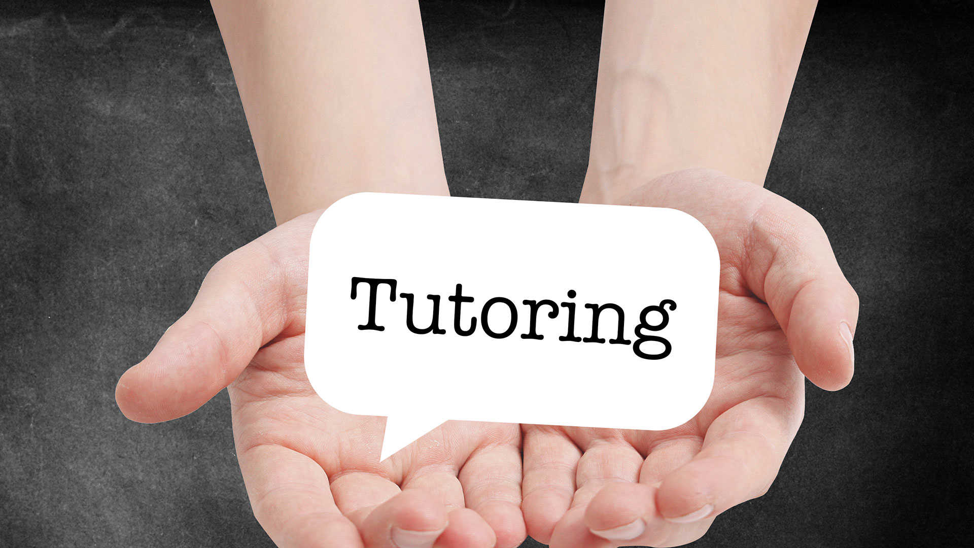 Hænder der holder et skilt med ordyden Tutoring