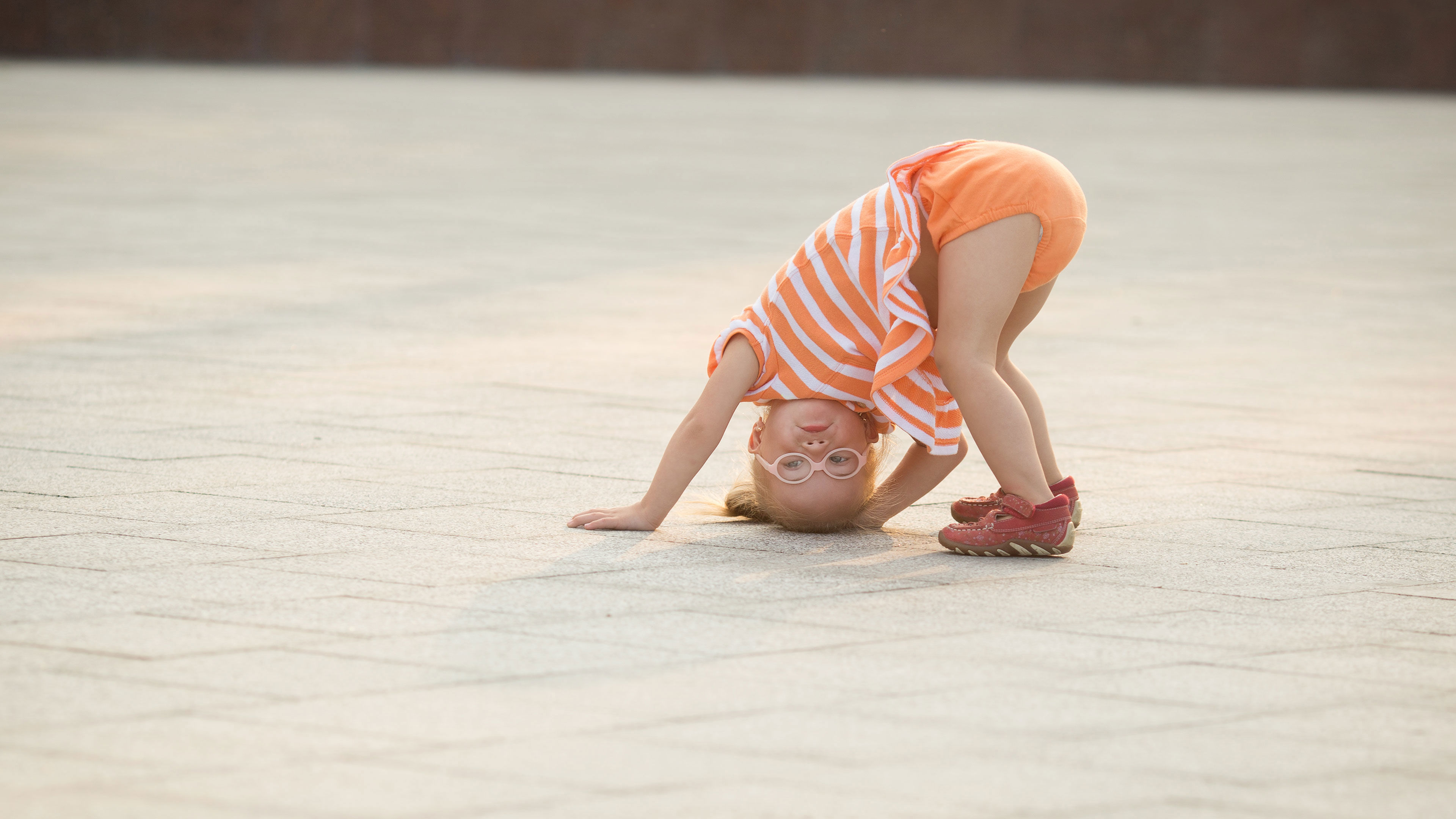 Lille pige med briller der har hovedet nedad