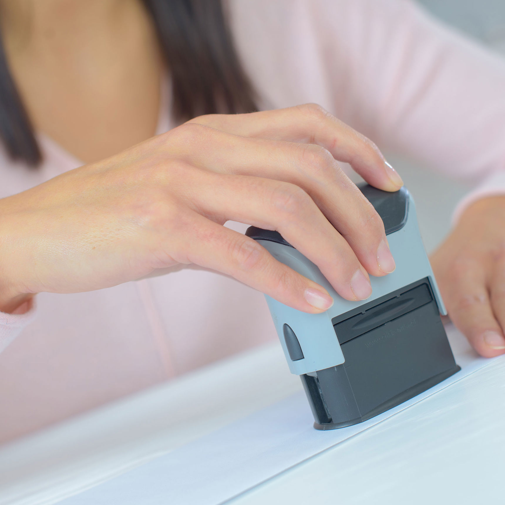 Hånd der sætter et stempel på et stykke papir