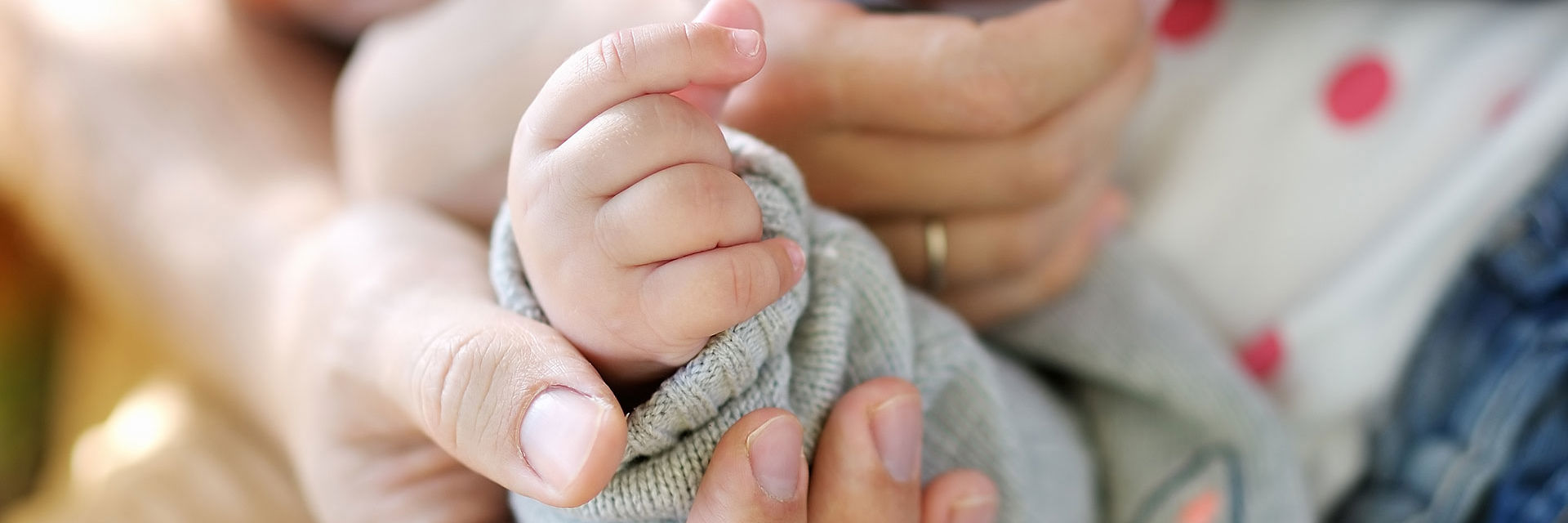 Voksenhænder der holder en babyhånd