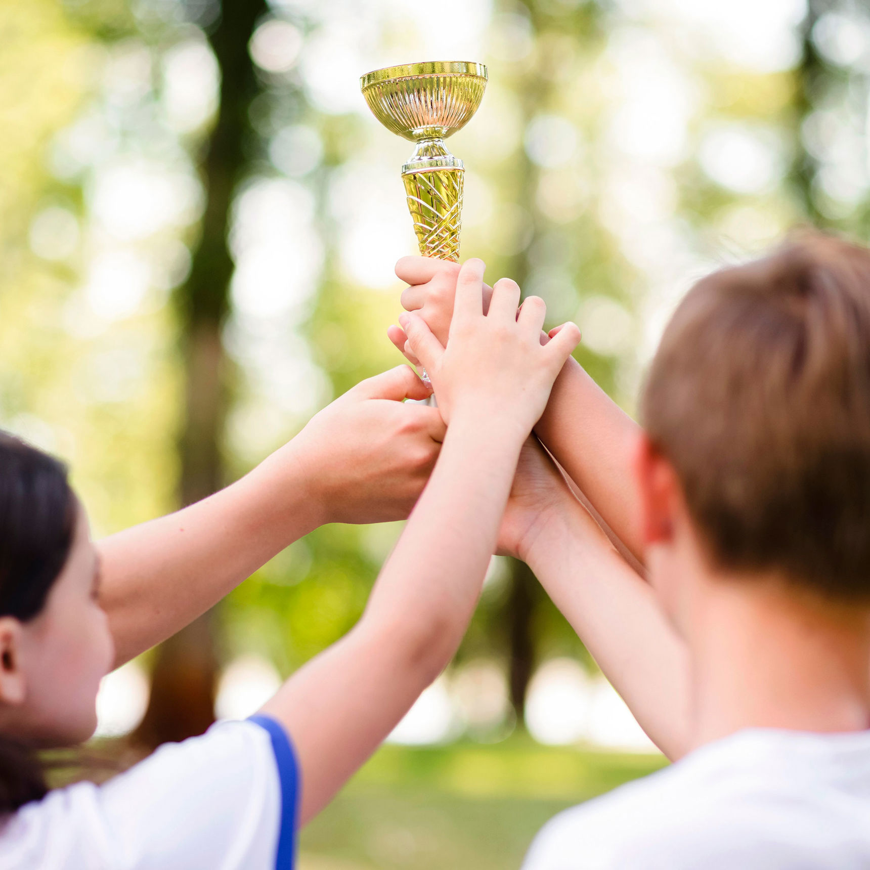 Børn der i fællesskab holder en pokal