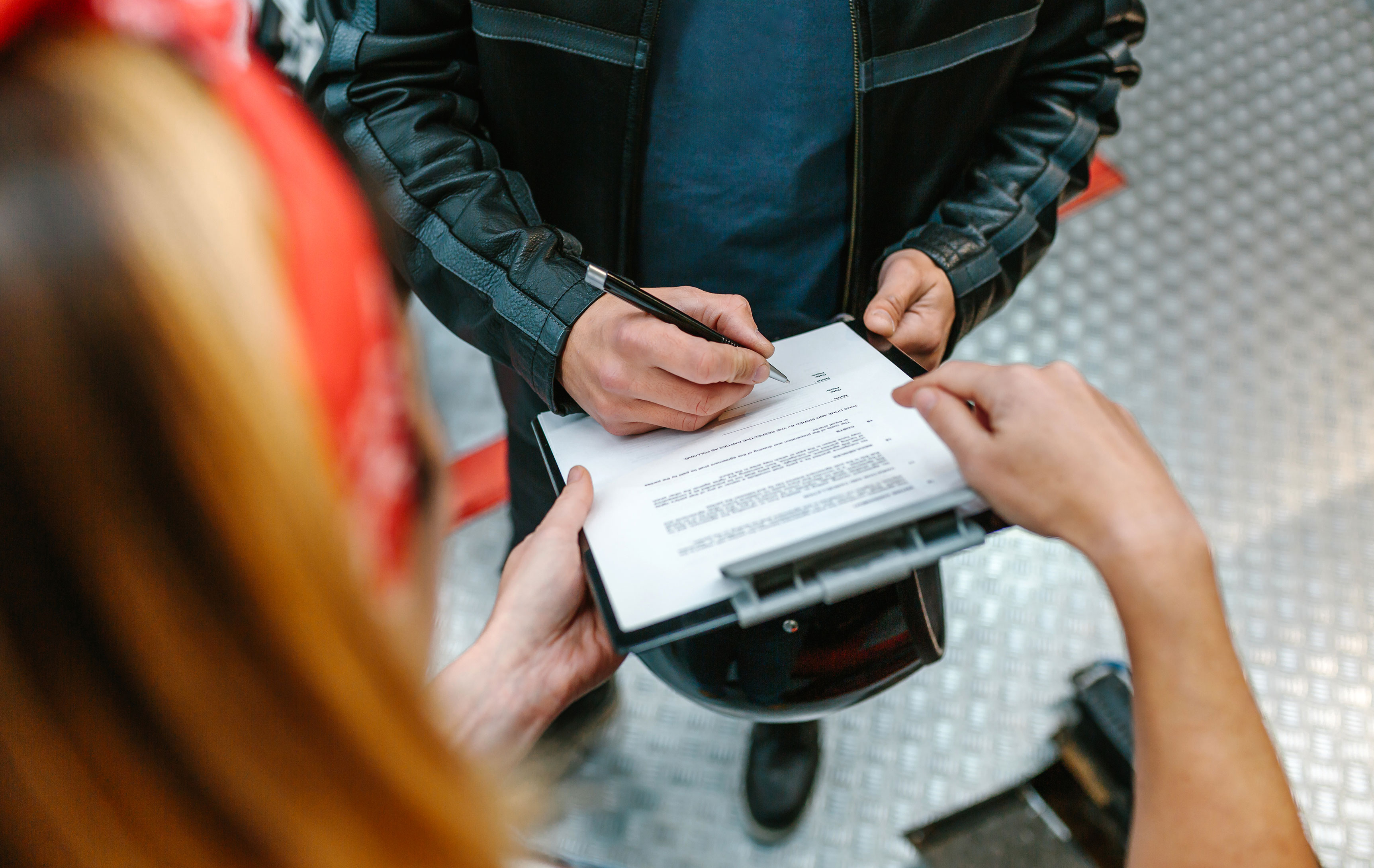 Kvinde og mand der sammen holder et klipboard til underskrift