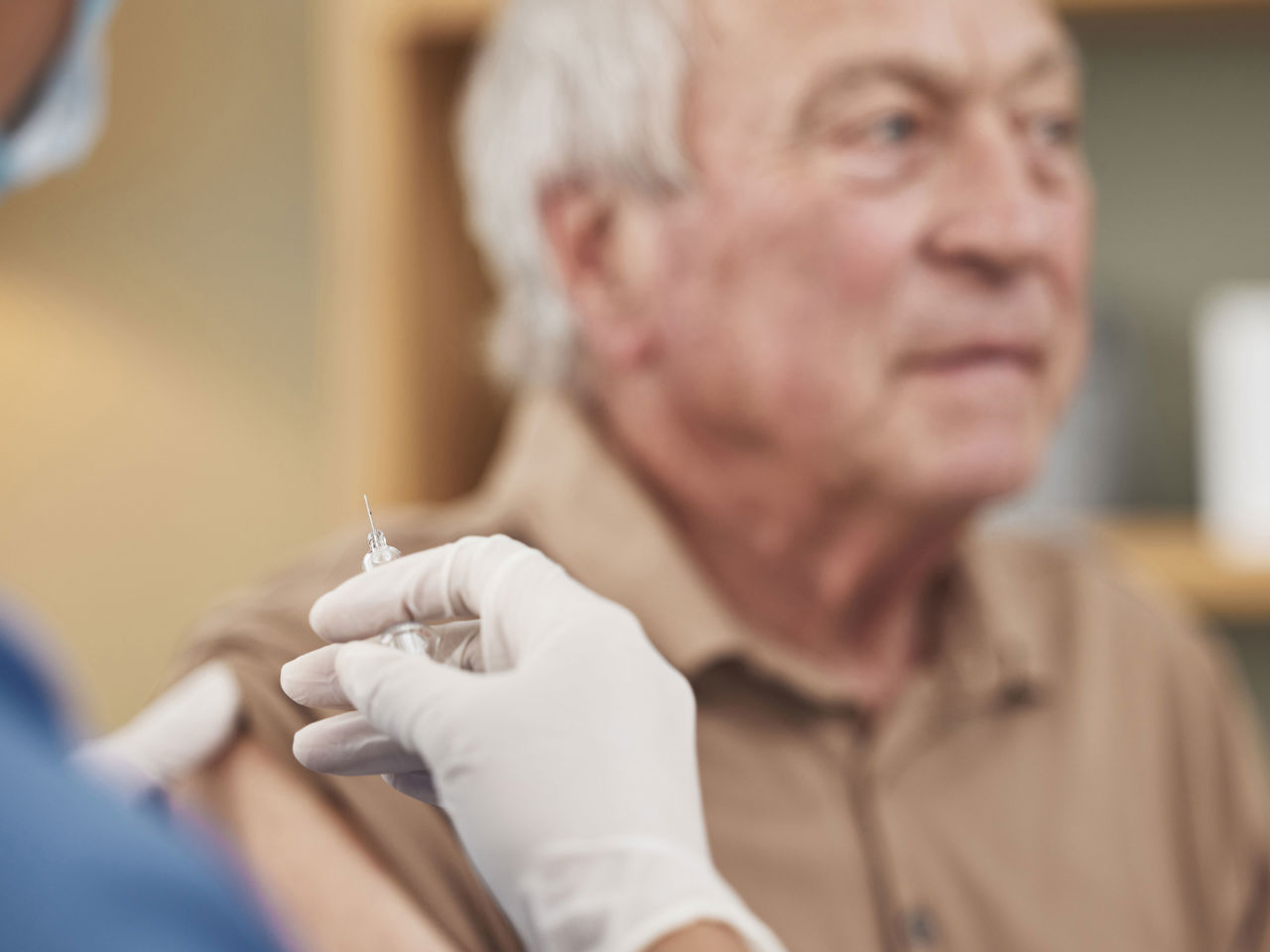 Ældre herre der venter på at blive vaccineret