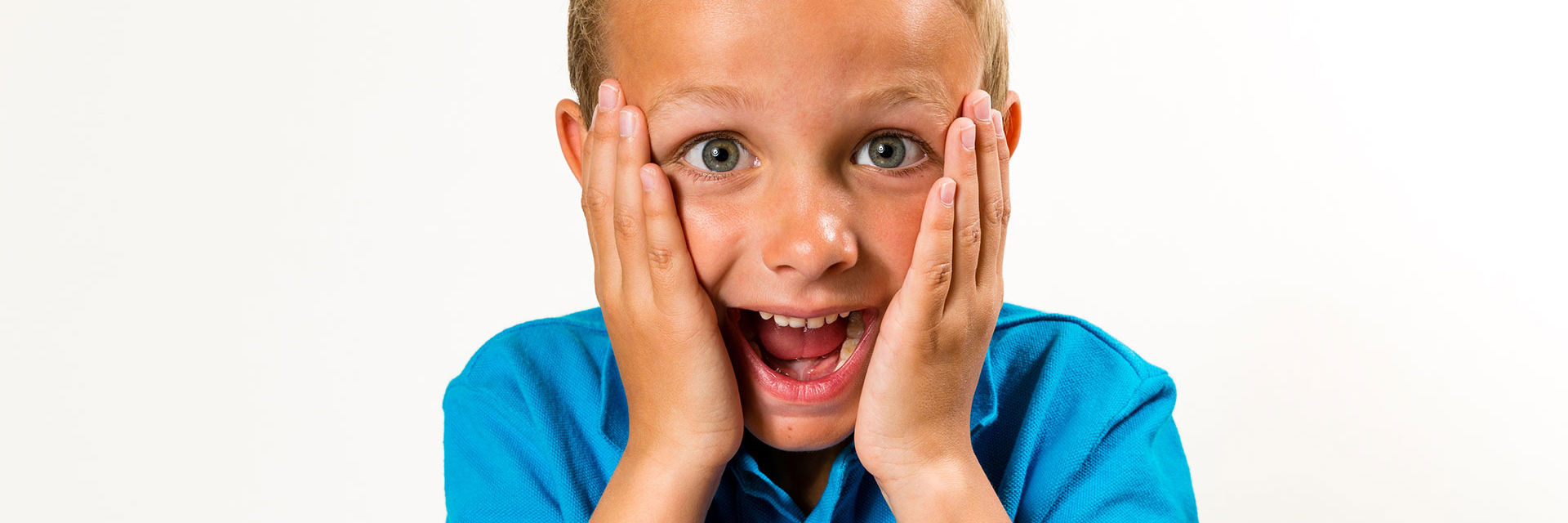 Dreng med åben mund og hænder på kinderne