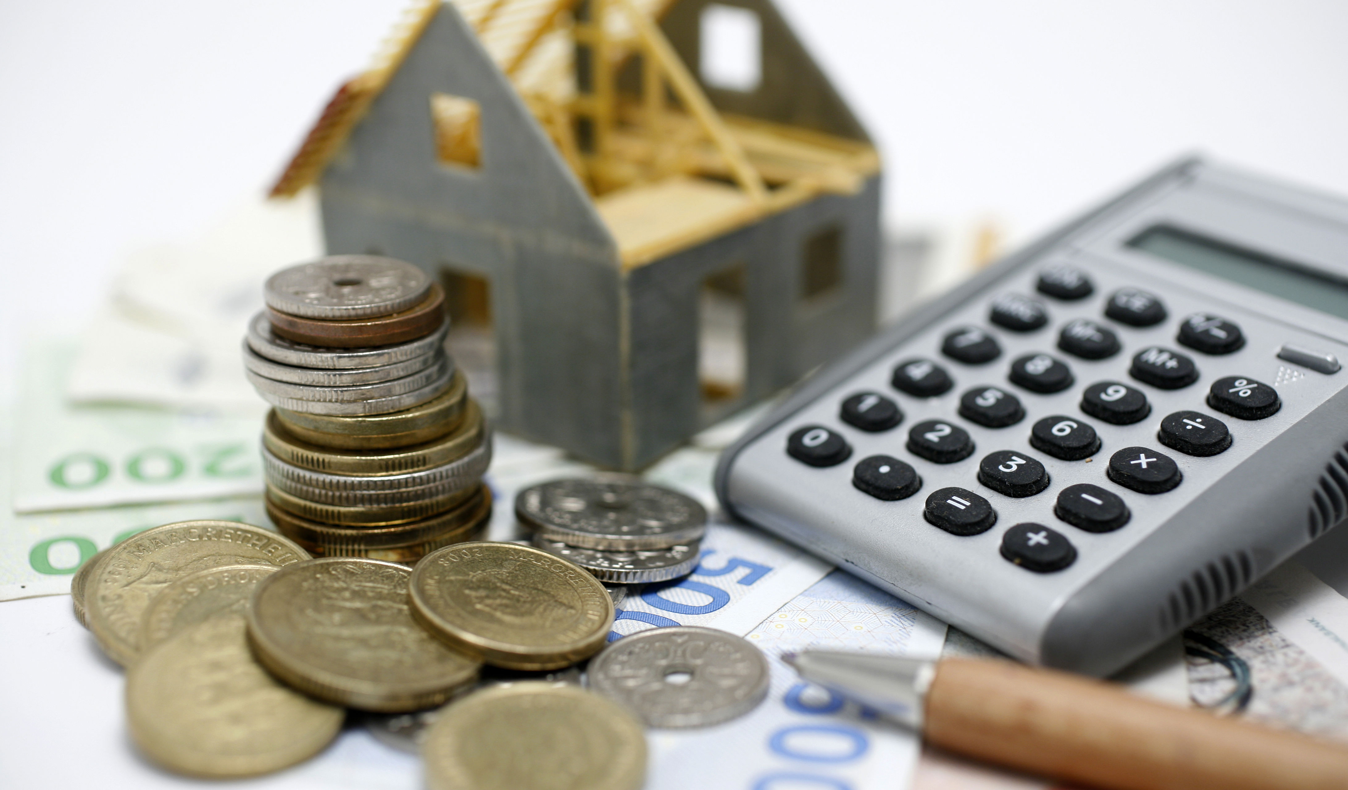 Penge, lommeregner og husfigur