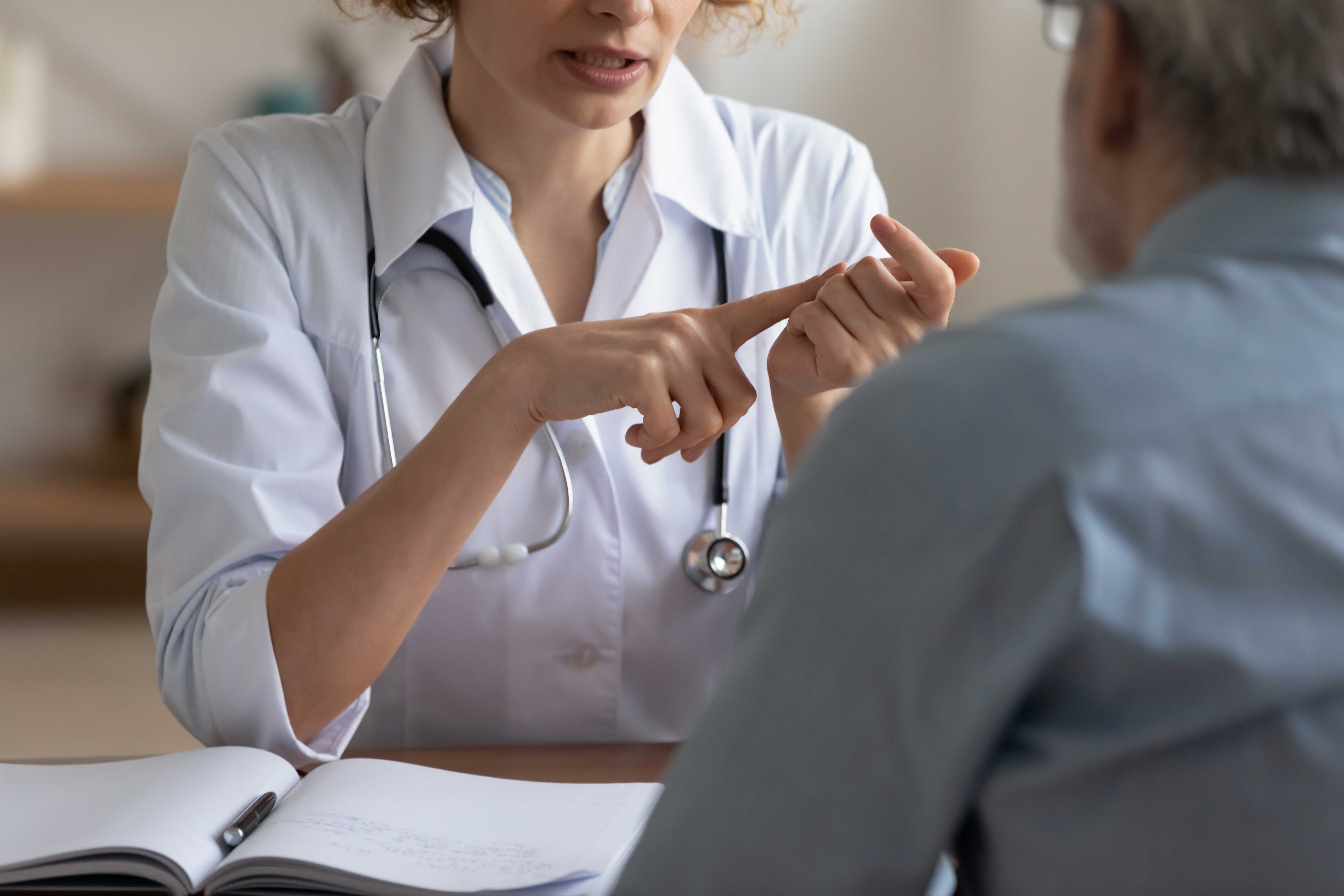 Kvindelig læge snakker med mand